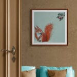 'A Berry Good Day!' captures a playful winter moment as a red squirrel, out foraging in the snow, drops his prized acorn in astonishment at the sight of a cluster of bright holly berries. A scene full of mischief, warmth, and woodland charm Painted by renowned UK wildlife artist Ann Richmond, the artwork comes alive with vibrant brush strokes over a richly textured canvas, capturing the delicate interplay of nature in a moment of quiet wonder. Each piece in The Wylde Ones is rendered in Richmond’s fresh, energetic, and gestural new style—a deliberate departure from her works in The Otherwurlde Collection. The backgrounds are carefully matched to hues from a heritage palette we affectionately call “Barrow & Fall”; complementing these striking and distinctive portrayals of British wildlife. Discover the original works and fine-art prints at Otherwurlde.com.