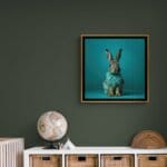 Leveret, created by innovative UK digital artist Gary Hyland, captures the stunning innocence of a baby hare, delicately colour-tinted to harmonise with a soft, graduated blue background. This enchanting piece from the Fauna Collection celebrates the purity and charm of nature through a minimalist yet captivating composition, where the blue accents in the leveret’s fur resonate with the serene backdrop. An impossibly cute and gentle vision, Leveret transports us to a timeless, unspoiled realm of natural beauty, blended with a subtle twist of colour. Discover original artworks and fine-art prints from this endearing series at Otherwurlde.com.