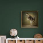 Donkey Foal, created by innovative UK digital artist Gary Hyland, captures the stunning innocence of a baby Donkey, delicately colour-tinted to harmonise with a graduated, earthy olive-green background. This enchanting piece from the Fauna Collection celebrates the purity and charm of nature through a minimalist yet captivating composition, where the subtle grey & gingery-brown accents in the Donkey's fur resonate with the backdrop. An impossibly cute and gentle vision, Donkey Foal transports us to a timeless, unspoiled realm of natural beauty, blended with a subtle twist of colour. Discover original artworks and fine-art prints from this endearing series at Otherwurlde.com.