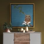 'Love in a Cold Climate...' is a loose sequel to the earlier piece 'Big Drip, Little Owl!'. In this latest painting, the featured character is a beautifully painted Horned Owl that has a little yellow snail sitting at the tip of one of its ears. Look closer: the snail has made contact with another that's balanced on an overhanging leaf! Little wonder that the owl looks so grumpy! Painted by renowned UK wildlife artist Ann Richmond, the artwork comes alive with vibrant brush strokes over a richly textured canvas, capturing the delicate interplay of nature in a moment of quiet wonder. Each piece in The Wylde Ones is rendered in Richmond’s fresh, energetic, and gestural new style—a deliberate departure from her works in The Otherwurlde Collection. The backgrounds are carefully matched to hues from a heritage palette we affectionately call “Barrow & Fall”; complementing these striking and distinctive portrayals of British wildlife. Discover the original works and fine-art prints at Otherwurlde.com.