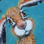 'Bad Hare Day…' is a whimsical study of a young hare sheltering beneath a leaf in a rainstorm — blissfully unaware that it’s dripping more water than it’s stopping. Raindrops splash and scatter across his fur in a scene full of humour, charm, and countryside mischief. A scene full of mischief, warmth, and woodland charm Painted by renowned UK wildlife artist Ann Richmond, the artwork comes alive with vibrant brush strokes over a richly textured canvas, capturing the delicate interplay of nature in a moment of quiet wonder. Each piece in The Wylde Ones is rendered in Richmond’s fresh, energetic, and gestural new style—a deliberate departure from her works in The Otherwurlde Collection. The backgrounds are carefully matched to hues from a heritage palette we affectionately call “Barrow & Fall”; complementing these striking and distinctive portrayals of British wildlife. Discover the original works and fine-art prints at Otherwurlde.com.