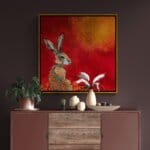 “Hare, Dryer…” presents a serene portrait of a hare at dawn, bathed in the soft warmth of a rising sun. Set against rich tones of red, yellow, and marigold, the hare rests calmly among oversized, abstracted flowers — a quietly radiant scene that speaks of warmth, stillness, and gentle renewal. Painted by renowned UK wildlife artist Ann Richmond, the artwork comes alive with vibrant brush strokes over a richly textured canvas, capturing the delicate interplay of nature in a moment of quiet wonder. Each piece in The Wylde Ones is rendered in Richmond’s fresh, energetic, and gestural new style—a deliberate departure from her works in The Otherwurlde Collection. The backgrounds are carefully matched to hues from a heritage palette we affectionately call “Barrow & Fall”; complementing these striking and distinctive portrayals of British wildlife. Discover the original works and fine-art prints at Otherwurlde.com.