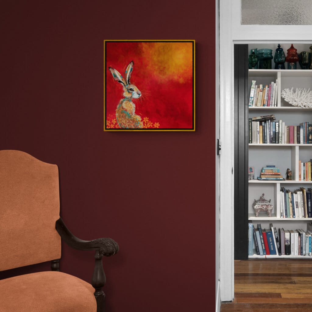 “Hare, Dryer…” presents a serene portrait of a hare at dawn, bathed in the soft warmth of a rising sun. Set against rich tones of red, yellow, and marigold, the hare rests calmly among oversized, abstracted flowers — a quietly radiant scene that speaks of warmth, stillness, and gentle renewal. Painted by renowned UK wildlife artist Ann Richmond, the artwork comes alive with vibrant brush strokes over a richly textured canvas, capturing the delicate interplay of nature in a moment of quiet wonder. Each piece in The Wylde Ones is rendered in Richmond’s fresh, energetic, and gestural new style—a deliberate departure from her works in The Otherwurlde Collection. The backgrounds are carefully matched to hues from a heritage palette we affectionately call “Barrow & Fall”; complementing these striking and distinctive portrayals of British wildlife. Discover the original works and fine-art prints at Otherwurlde.com.